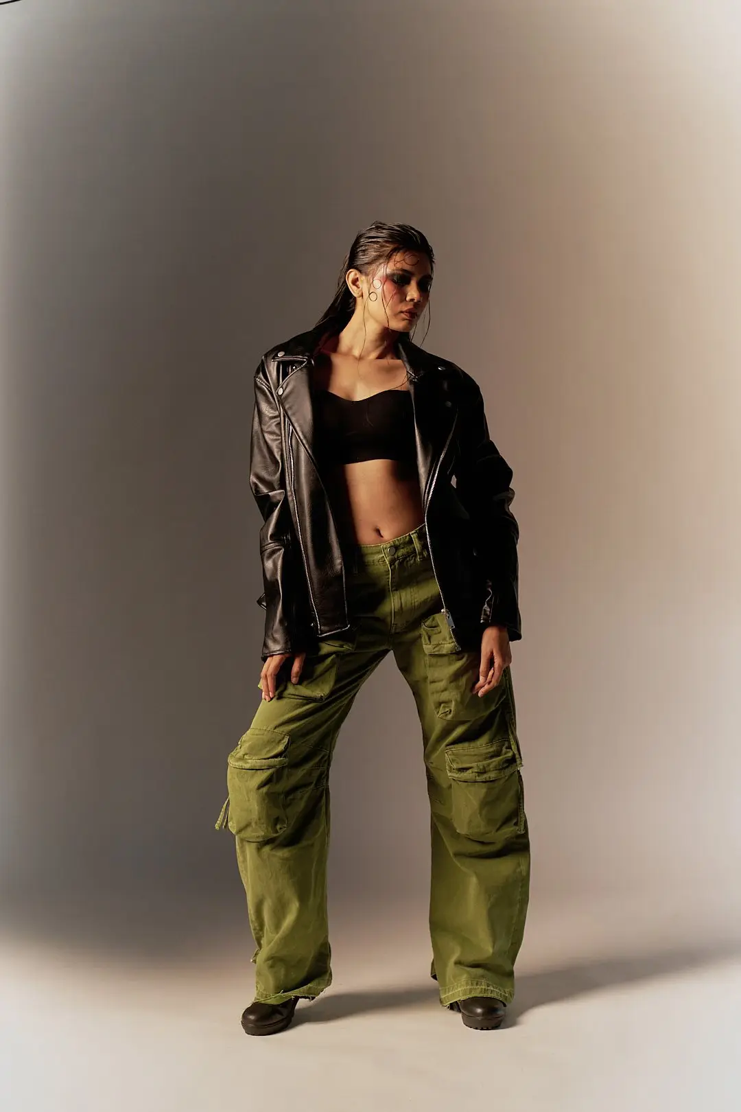 A black leather jacket, green cargo and violet shades on warm grey - one look, four frames.