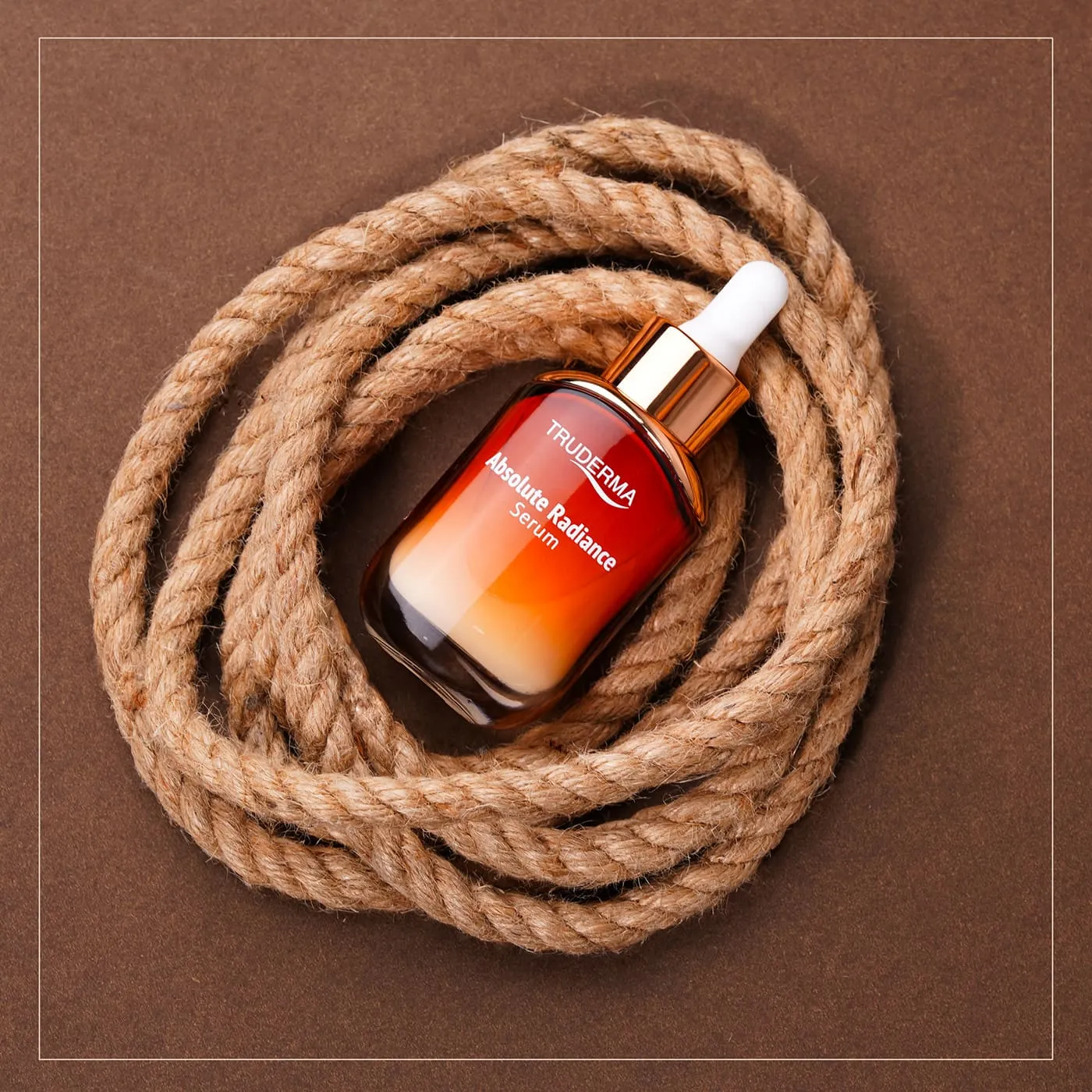 Serum bottle in a coil of jute rope on terracotta