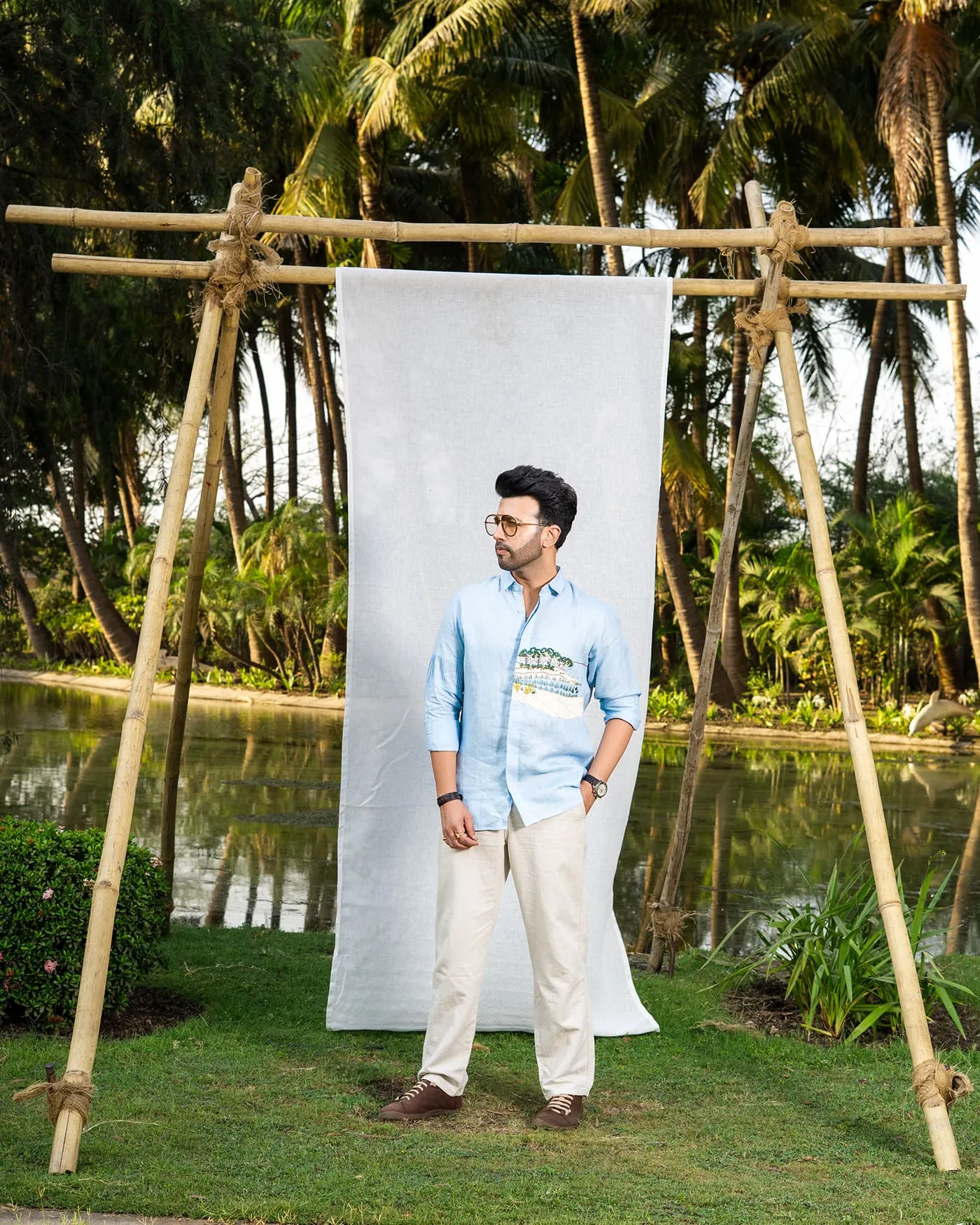 A menswear campaign - resort palms, a backdrop strung between bamboo, warm interiors.