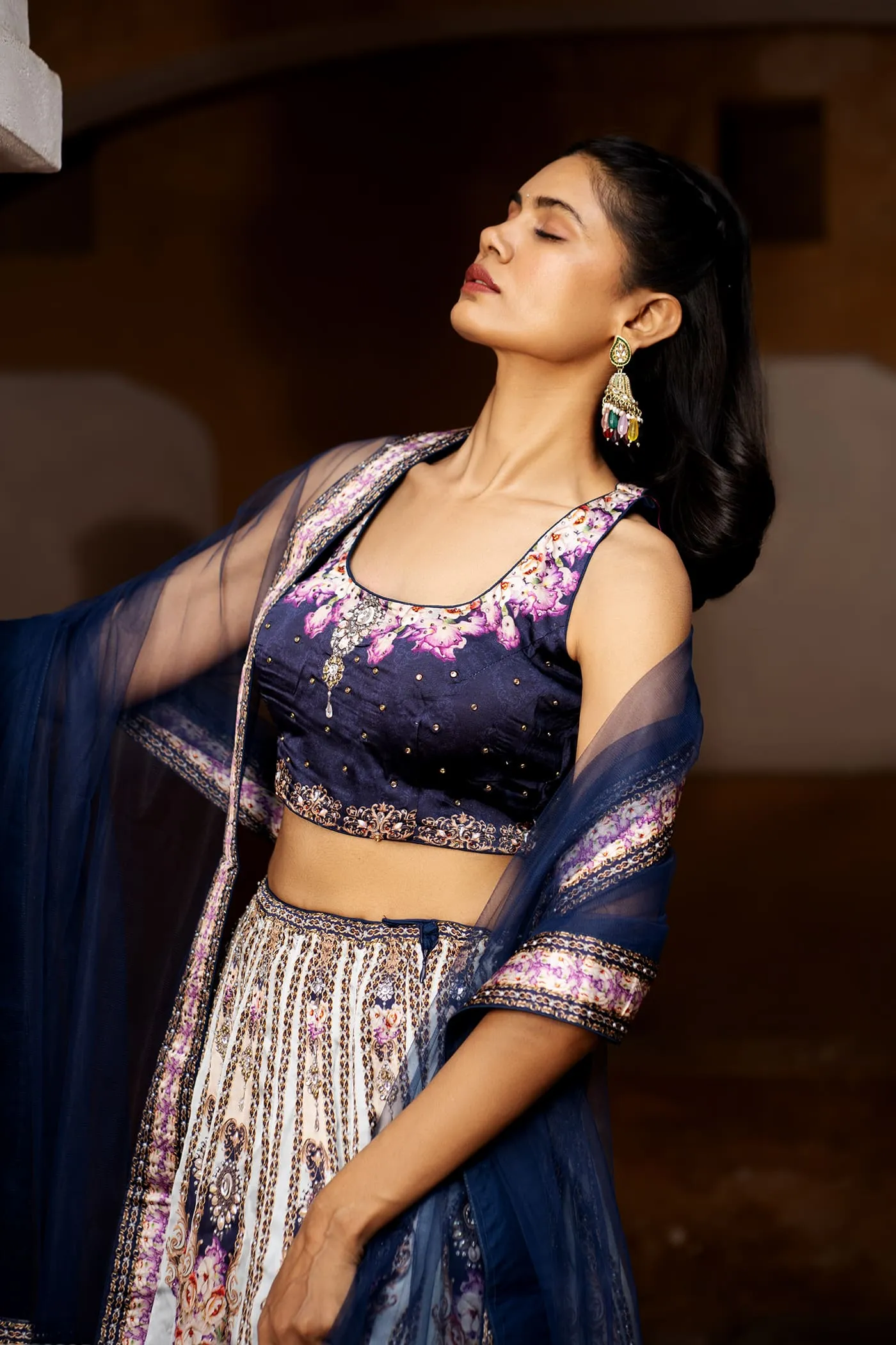 Model in a navy embroidered lehenga with the dupatta in motion